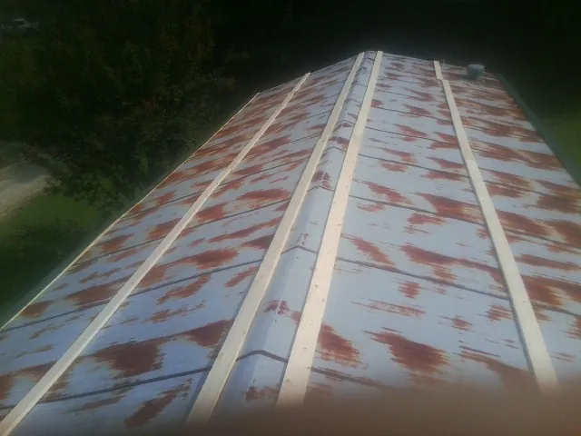 Rusted metal roof panels with new wood purlins before replacement — Storm Damage Roof Repair in Dunmor by Roofing Brothers