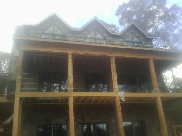 Dormers and porch framing on a large log home under construction — Roof Coating work by our crew in Dunmor