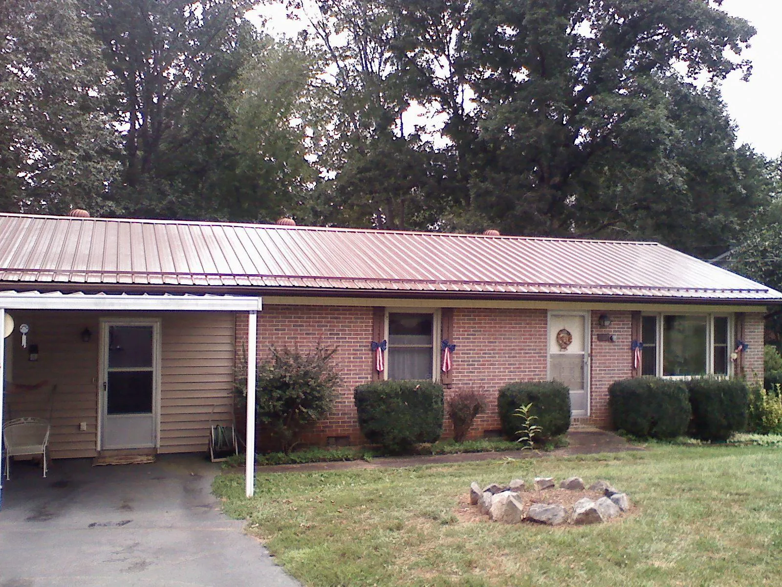 Bronze metal roof and carport on a brick ranch home — Roof Repair work by our crew in Dunmor